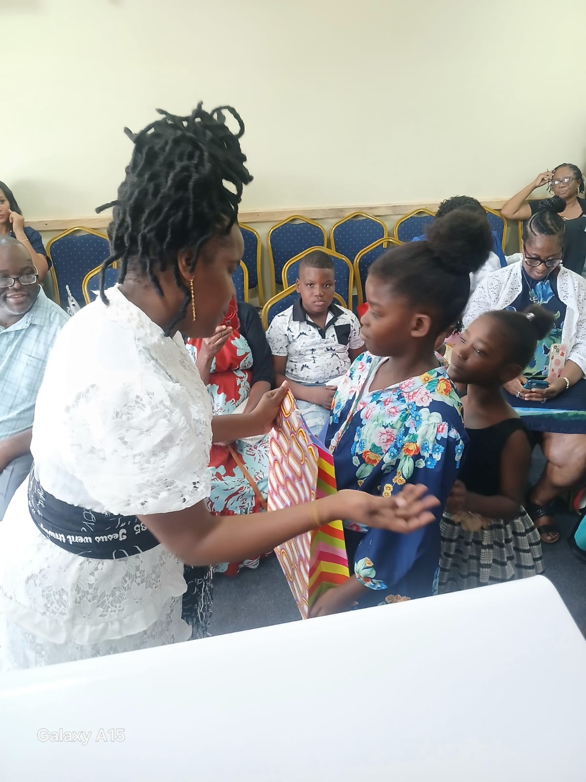Church leader presenting a gift to children during Back to School 2026