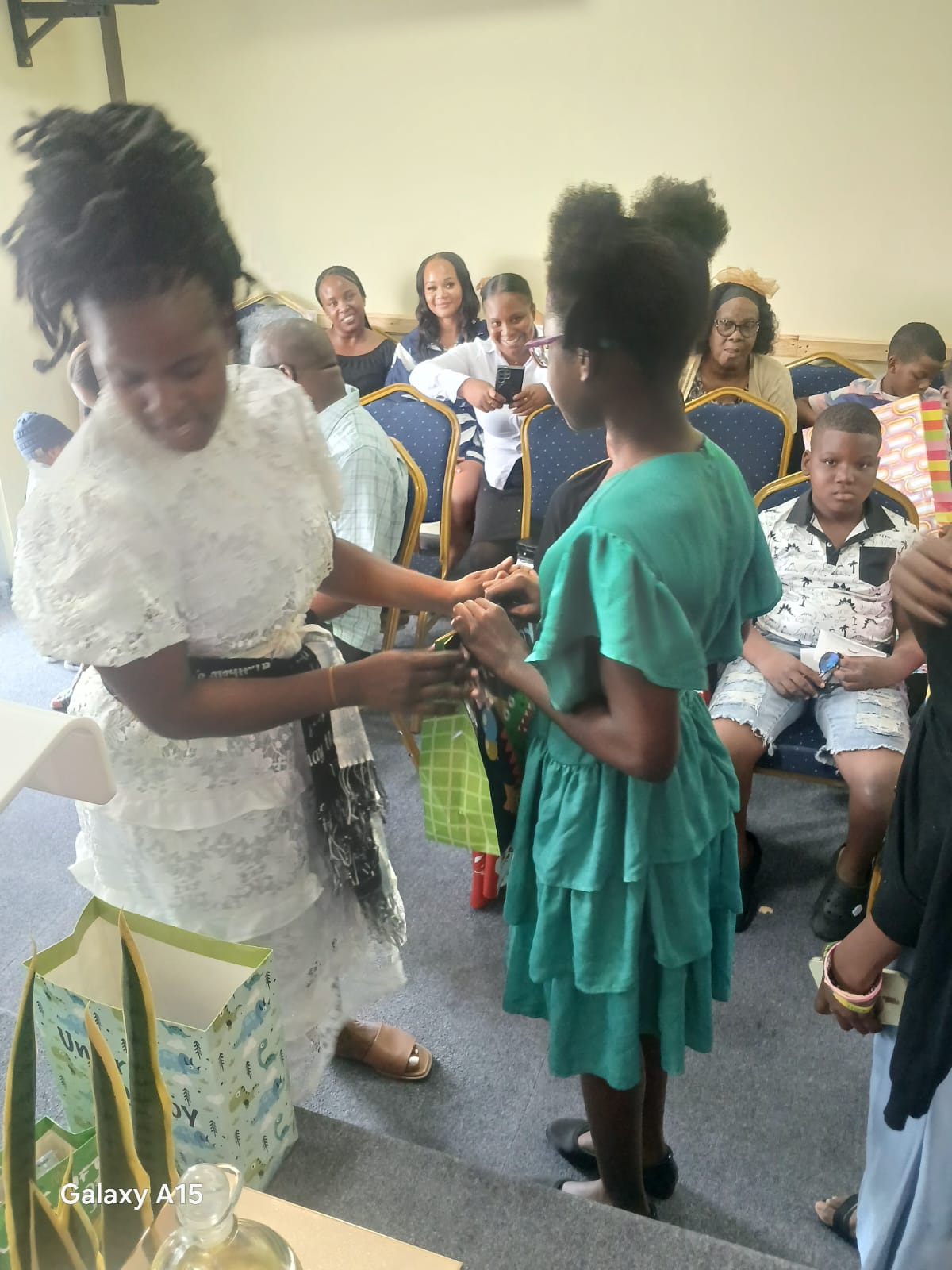 Church leader giving a gift to a girl in a green dress