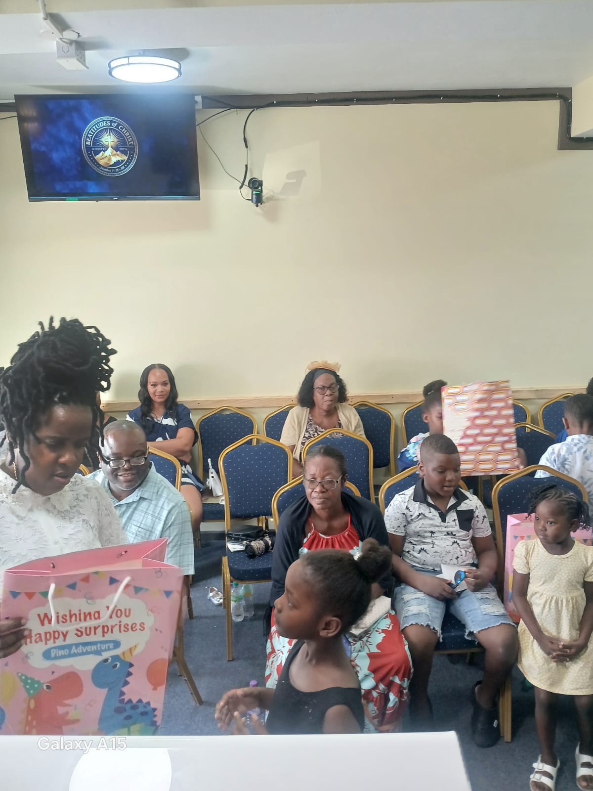 Child displaying a gift while the congregation looks on